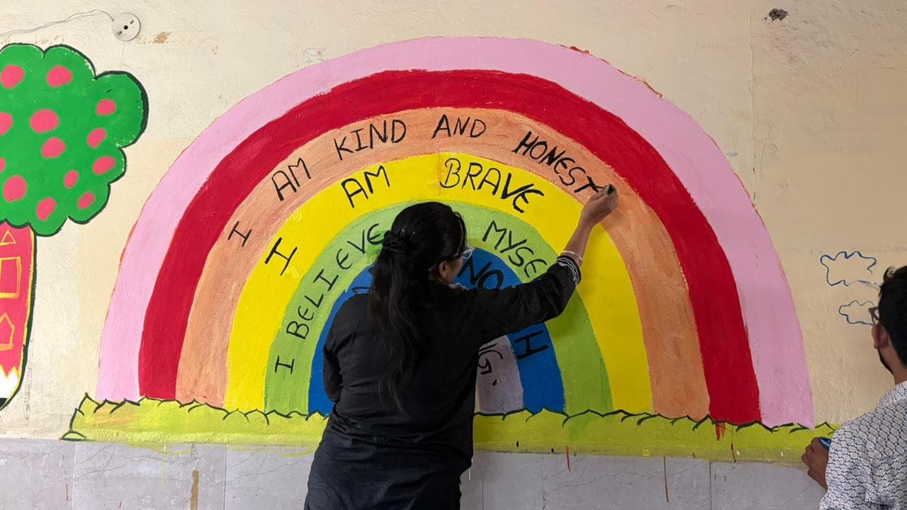 Volunteers painting a school wall