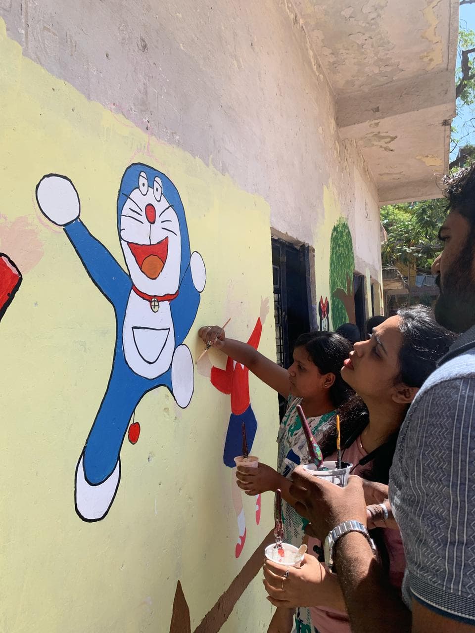 Volunteers painting a school wall